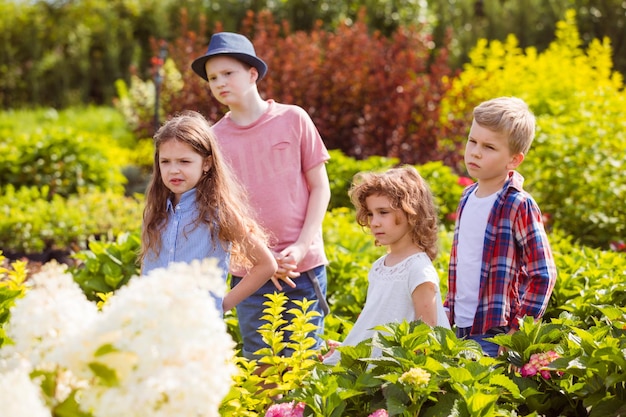 I bambini scelgono i fiori nel negozio di giardinaggio all'aperto