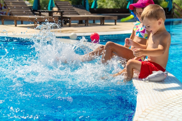 I bambini schizzano i piedi in piscina. Messa a fuoco selettiva.