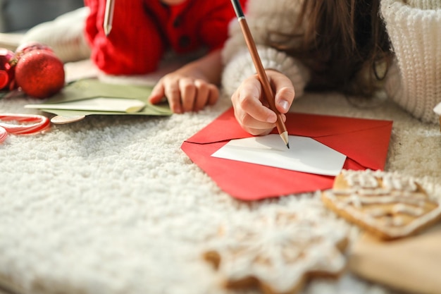 I bambini scrivono una lettera alla foto atmosferica festiva di Babbo Natale