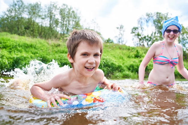 I bambini si bagnano nel fiume il giorno d'estate