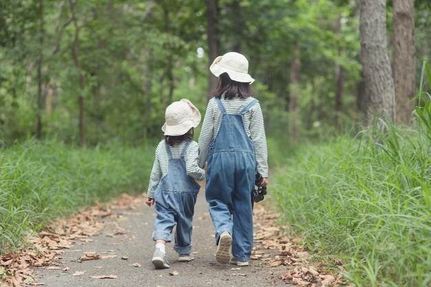 I bambini si dirigono al campeggio per famiglie nella foresta Passeggiata lungo il percorso turistico. Strada del campeggio. Concetto di vacanza di viaggio in famiglia.