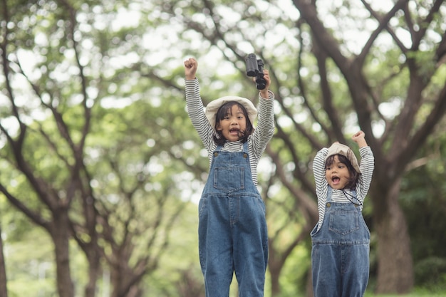 I bambini si dirigono al campeggio per famiglie nella passeggiata nel bosco lungo il percorso turistico. strada del campeggio. concetto di vacanza di viaggio in famiglia.