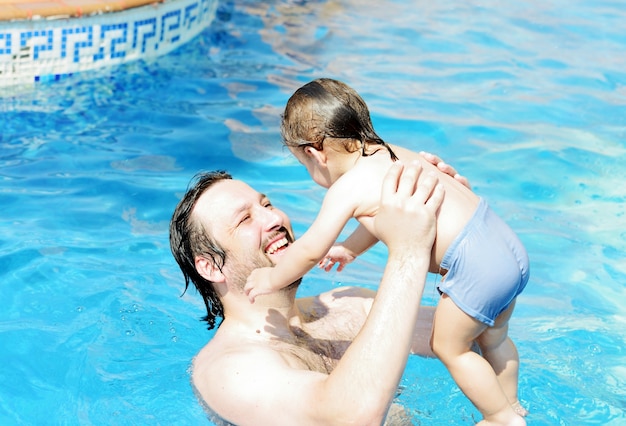 I bambini si divertono a giocare con l&#39;acqua sulla piscina estiva