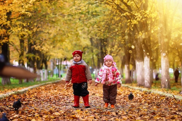 I bambini si divertono durante una passeggiata nel parco autunnale