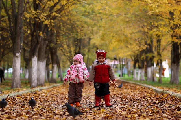 I bambini si divertono durante una passeggiata nel parco autunnale