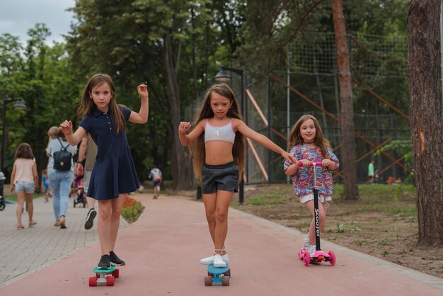 i bambini si divertono su scooter e skateboard