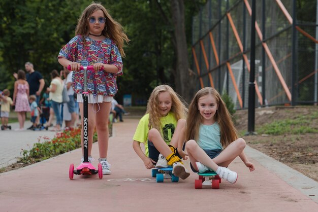 i bambini si divertono su scooter e skateboard