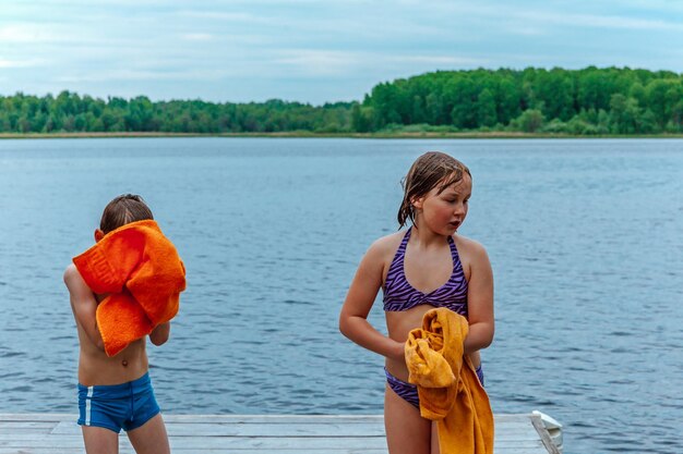 I bambini si puliscono con gli asciugamani dopo il bagno nel lago