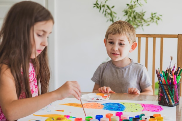 I bambini sono felici di disegnare con i colori su carta grande