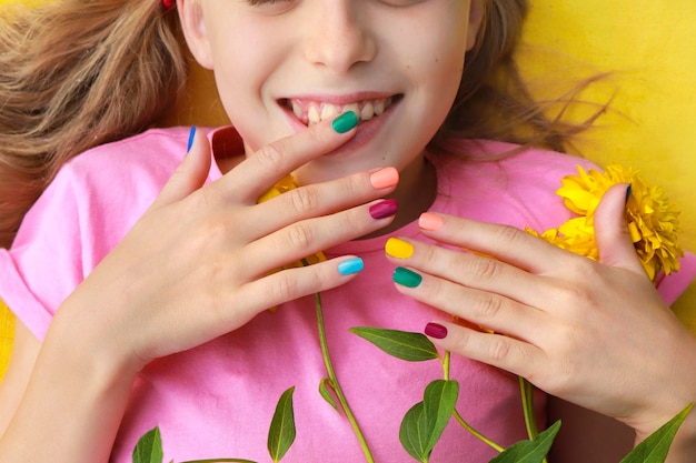 I bambini sono manicure multicolore su un bambino con fiori