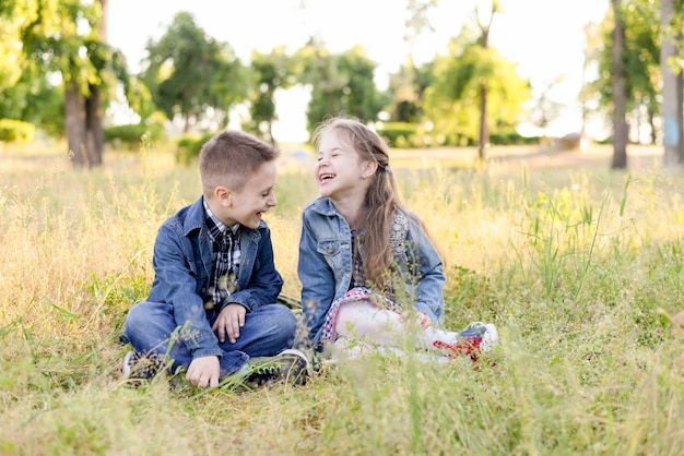 I bambini sorridenti emozionanti nel campo verde giocano insieme