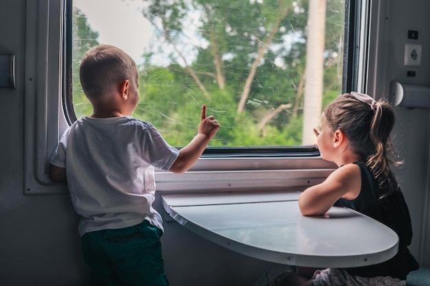 I bambini sul treno guardano fuori dal finestrino