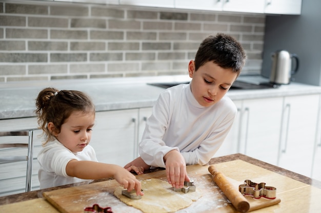 I bambini tagliano i biscotti dall'impasto