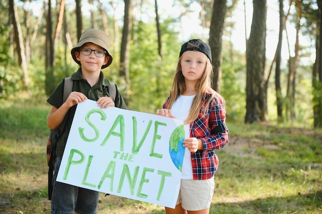 I bambini tengono un poster Salva il pianeta