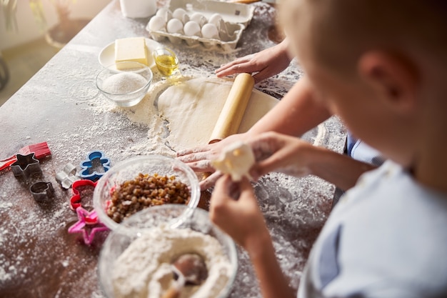 I bambini usano il mattarello per stendere l'impasto