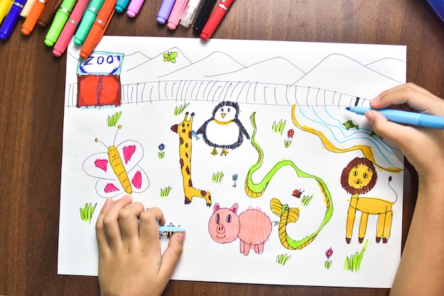 I bambini usano pennarelli colorati per disegnare animali immaginari su carta bianca