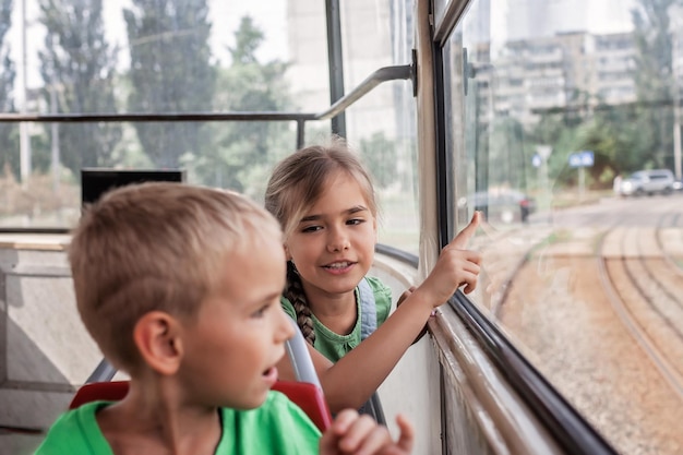 I bambini viaggiano in tram vuoto e guardano la finestra con interesse il tram cittadino dei trasporti pubblici