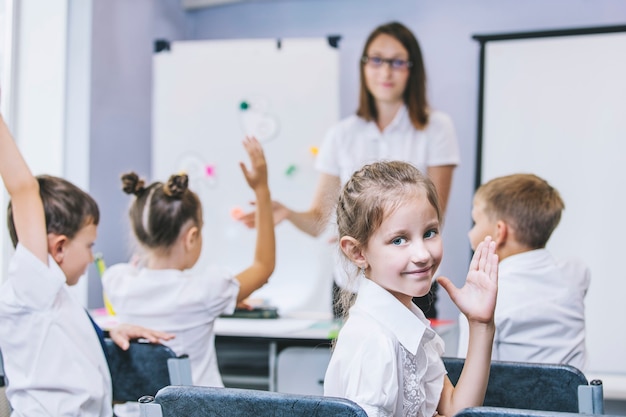 I bei bambini sono studenti insieme in una classe a scuola e ricevono l'istruzione con l'insegnante