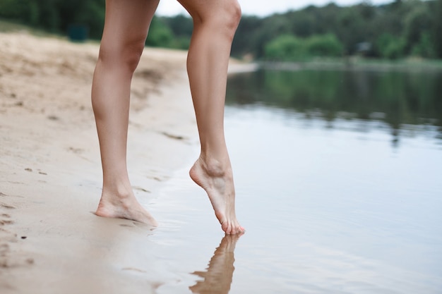 I bei piedini femminili entrano nell'acqua