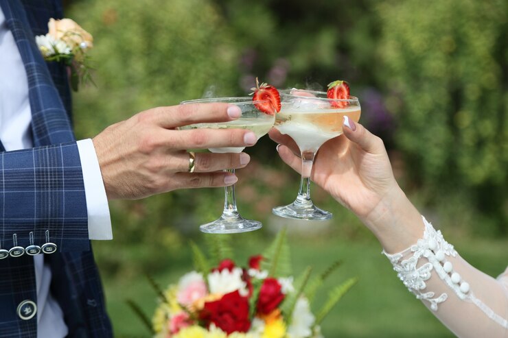 I bicchieri di champagne nelle mani degli sposi.