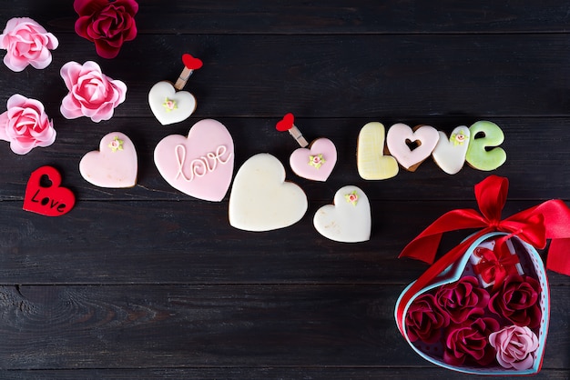 I biscotti del biglietto di S. Valentino in forma di cuore su fondo di legno scuro