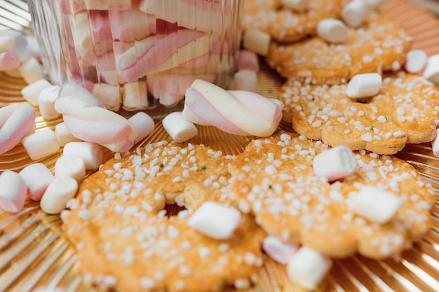 I biscotti giacciono su un piatto dorato con marshmallow. L'umore della felicità è la vigilia di Natale. foto