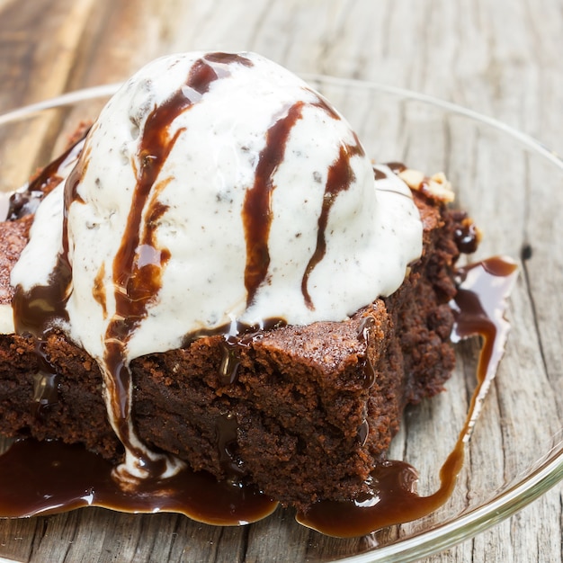 I brownies fatti in casa con gelato in cima e salsa di cioccolato sono topping.