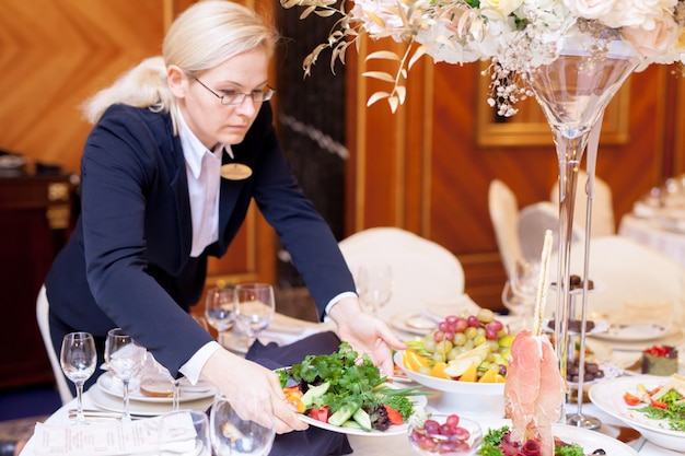 I camerieri apparecchiano i tavoli nel ristorante per il banchetto