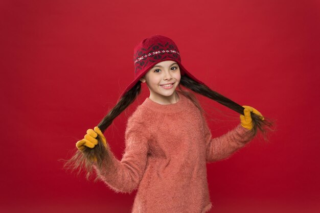 I capelli invidiabilmente lunghi sono appena accaduti Ragazza felice tenere lunghe ciocche sfondo rosso Bambino sorriso con lunghi capelli castani Corvo capelli folti e lunghi Routine di cura dei capelli per l'inverno