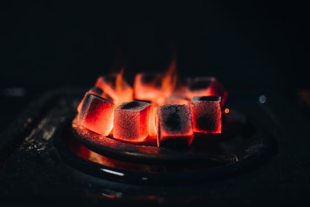 I carboni ardenti per Shisha si scaldarono sul fornello in un bar con narghilè