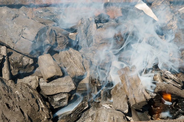 I carboni d&#39;ardore in un barbecue del carbone grigliano il fumo del fuoco