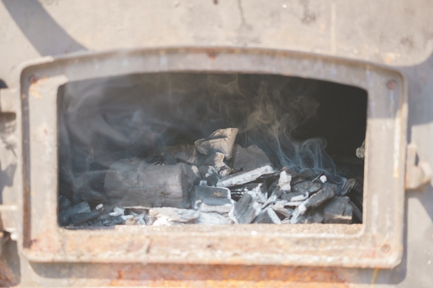 I carboni d&#39;ardore in un barbecue del carbone grigliano il fumo del fuoco