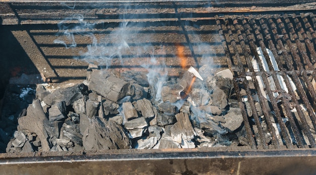 I carboni d&#39;ardore in un fumo del carbone del carbone del barbecue