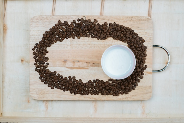 I chicchi di caffè sono fatti racchiusi intorno alle tazze di caffè che si trovano sul tabellone.