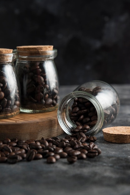 I chicchi di caffè sulla composizione della tavola di legno scuriscono il backround grigio