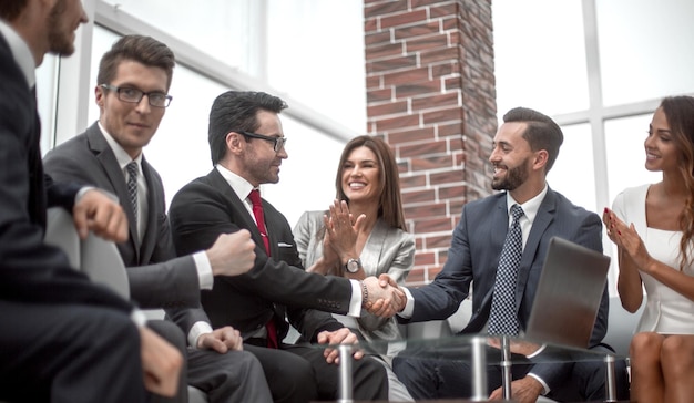 I colleghi applaudono i partner commerciali a una riunione d'affariconcetto di partnership