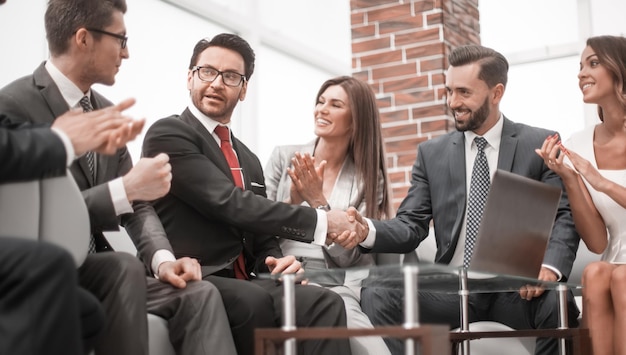 I colleghi applaudono i partner commerciali durante una riunione di lavoro