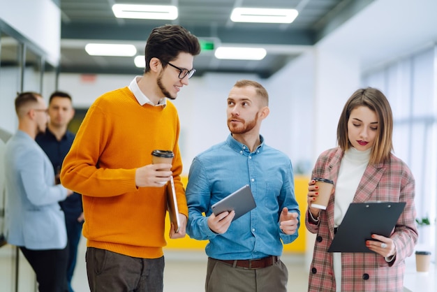 I colleghi con il caffè stanno discutendo di un nuovo progetto di business nell'ufficio creativo Studio di pianificazione