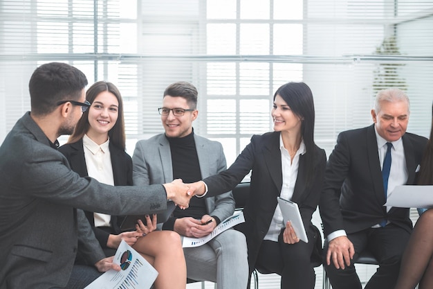 I colleghi di lavoro si salutano nella sala conferenze. concetto di cooperazione