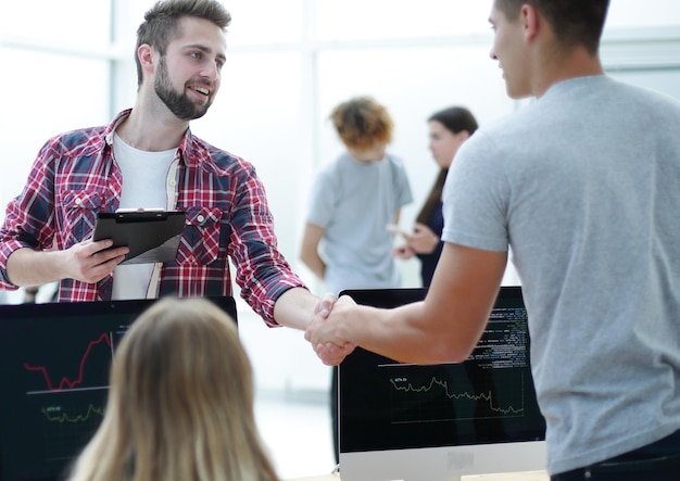 I colleghi di lavoro si stringono la mano sul posto di lavoro