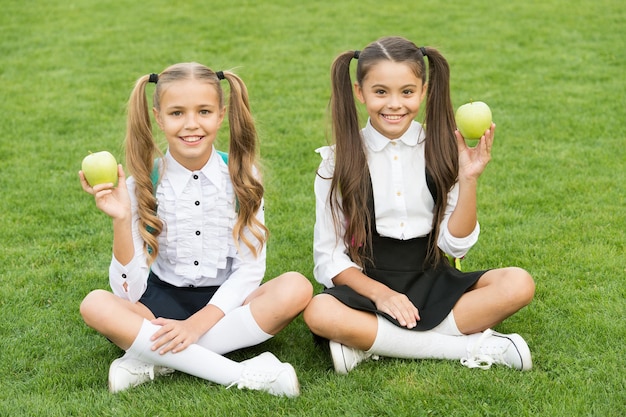 I compagni di classe delle ragazze mangiano un pranzo scolastico sano, concetto di infanzia felice.