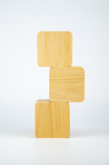 I cubi di legno vuoti sono impilati a forma di torre, uno sopra l'altro. i blocchi sono allineati verticalmente su sfondo bianco. concetto di business, interazione, crescita. Modello per il design, spazio per il testo