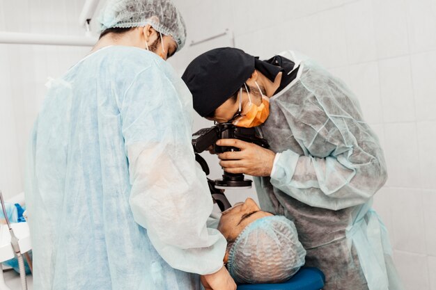 I dentisti eseguiranno un'operazione, il posizionamento dell'impianto. Operazione reale. Estrazione del dente, impianti. Uniforme professionale e attrezzature di un dentista. Assistenza sanitaria Dotazione di un posto di lavoro medico. Odontoiatria