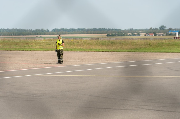 I dipendenti dell'aeroporto sono sulla pista Il territorio dell'aeroporto privato è recintato con filo spinato e una recinzione Il controllore del traffico dirige l'aereo