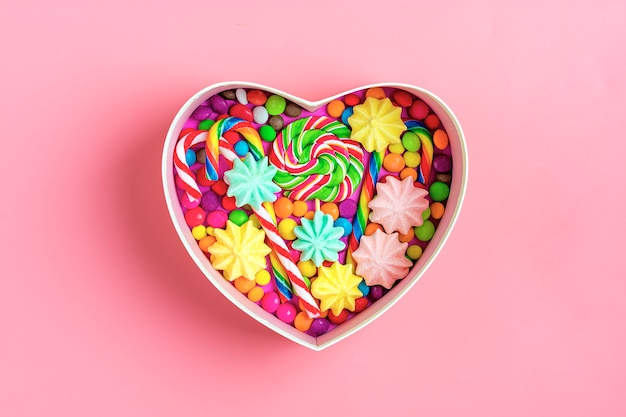 i dolci al cioccolato mix si trovano a forma di scatola regalo di cuore su sfondo colorato