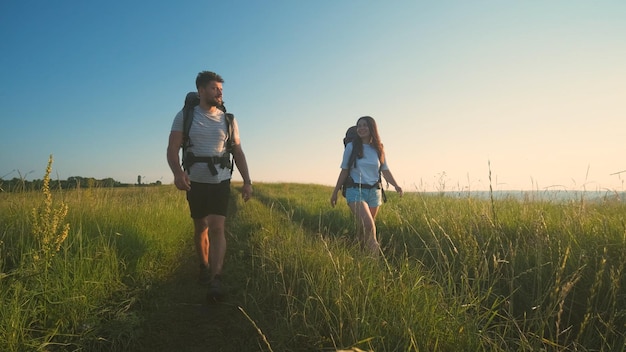 I due viaggiatori che camminano con gli zaini su uno sfondo di cielo blu