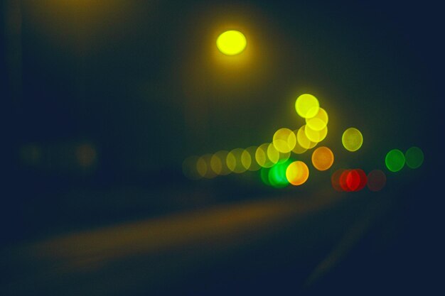 I fari di un'auto in arrivo attraversano l'oscurità della città notturna bokeh