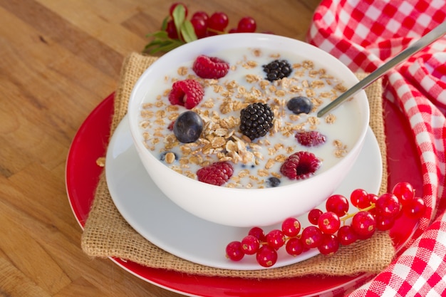 I fiocchi d'avena con frutti di bosco sulla tavola di legno