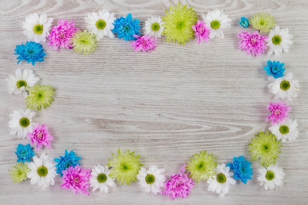 I fiori della struttura rotonda si avvolgono su fondo di legno bianco