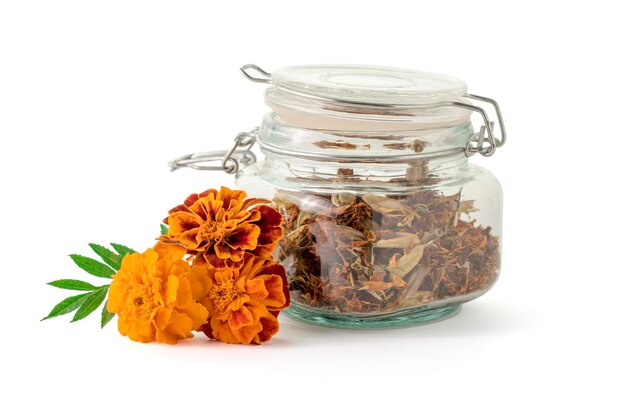 I fiori di calendula si asciugano in un barattolo di vetro e sono freschi isolati su uno sfondo bianco Medicina popolare